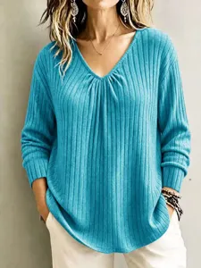 Close up detail of casual V-neck ribbed long sleeve top showing fine knit texture.