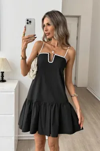 Detailed view of women's elegant black camisole dress with white scalloped trim.