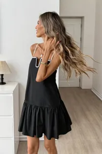 Elegant black summer slip dress with white scalloped trim and sweet ruffle hem detail.