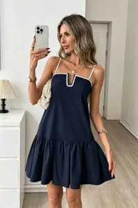 Navy blue spaghetti strap mini dress with white scalloped V-neck trim and pleated hem detail.