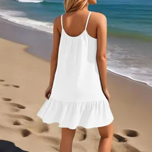 Gedetailleerd overzicht van de witte strandjurk met fijne spaghettibandjes en volantzoom.