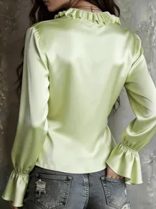 Detailed back view of a light green satin blouse featuring elegant ruffle collar and flared long sleeves.
