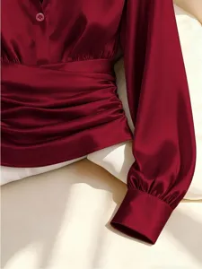 Wine red satin blouse detail, pleated waist and lapel design, elegant autumn women's top.