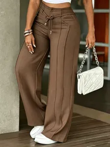 Detailed view of brown casual wide leg pants with front crease, drawstring waist and drape effect.