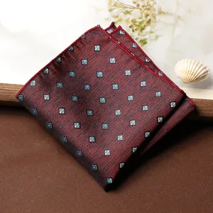 Dettaglio ravvicinato della elegante pochette da taschino rossa con raffinato motivo geometrico blu.