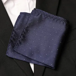 Detail view of men's dark blue pocket square with subtle white dots, elegant suit accessory.