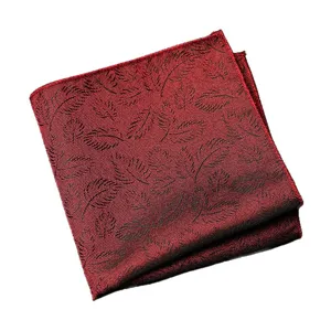 Pochette de costume rouge classique pour homme avec motif de feuilles noires élégantes.
