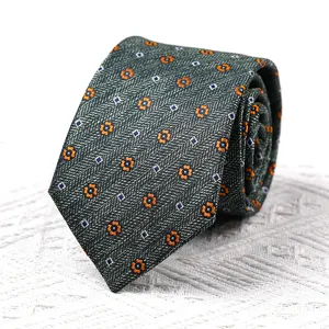 Detailaufnahme einer eleganten dunkelgrünen Krawatte mit feinen orangefarbenen Blumen und blauen Mustern.
