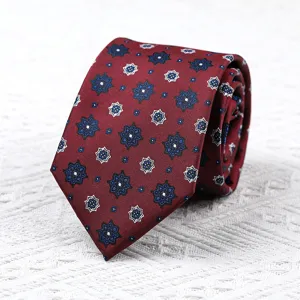 Detailaufnahme einer eleganten bordeauxroten Krawatte mit blau-weissem Sternen-Muster.