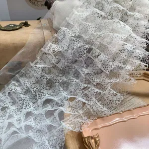 Detail shot of 7-layer pleated white lace trim, delicate ruffled mesh fabric for DIY crafts.