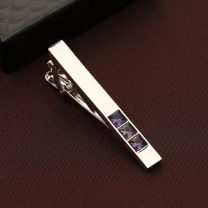 Pince à cravate argentée pour homme avec trois cristaux violets carrés pour tenue formelle.