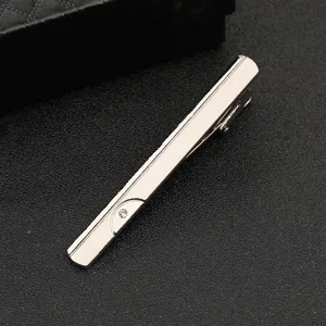 Detail shot of silver tie clip with rhinestone, premium metal business accessory close-up.
