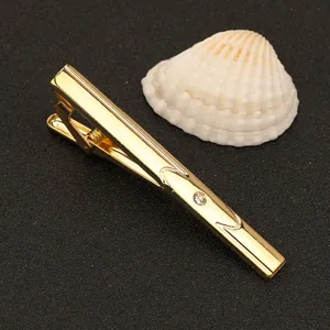 Primer plano detallado del elegante alfiler de corbata dorado con brillante toque de estrás.