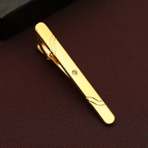 Gold metal tie clip for men, featuring sparkling crystal and chic wavy engraved details.
