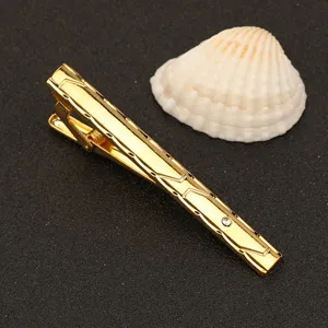 Detalle de primer plano de pisacravatas dorado de metal con estrás para ropa formal.