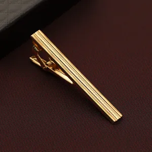 Goldene Krawattenklammer Detailaufnahme aus Metall mit strukturierter Oberflaeche fuer Herren Anzuege.