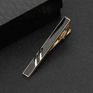 Detailaufnahme einer stilvollen goldenen Herren Krawattenklammer mit schwarzer Geometrie.