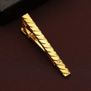 Gold-tone metal tie clip featuring diagonal textured pattern and sparkling crystal detail.