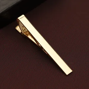 Vista dettagliata della fermacravatta in metallo dorato, design minimalista classico uomo.