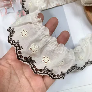 Detailed shot of 5.5cm cotton lace trim with brown butterfly and white flower embroidery.