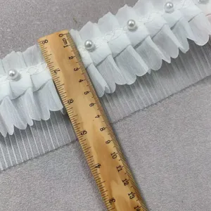 White ruffled lace trim detail with faux pearls, showcasing fabric texture and width measurement.