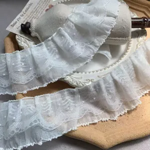 Close-up of 3-layer white polka dot lace chiffon ruffle trim for DIY crafts and doll dresses.