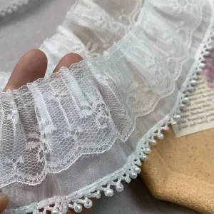 Close-up detail of white double-layer chiffon pearl lace trim, showing fine texture.