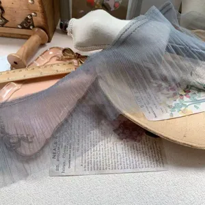 Detailed view of grey pleated tulle lace trim, fine mesh fabric for creative DIY crafts.
