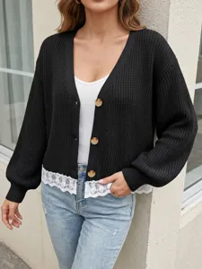 Vue détaillée du cardigan en tricot noir avec ourlet en dentelle et boutons.