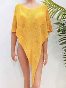 Detalle cercano del top poncho de punto calado amarillo para mujer con dobladillo irregular.