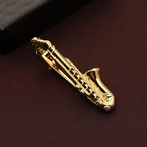 Primo piano sul dettaglio del fermacravatta a sassofono dorato, elegante texture metallica per uomo.
