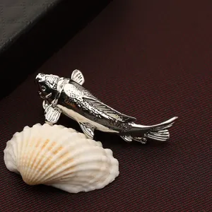 Primo piano dettaglio fermacravatta a forma di pesce koi argento, elegante accessorio da uomo.