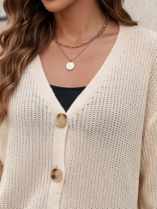 Détail rapproché du cardigan tricoté pour femme à col V, fermeture à boutons et texture.