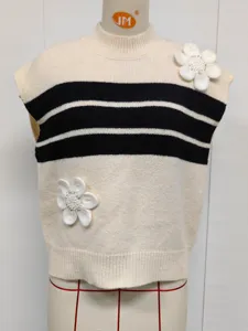 Detalle de chaleco de punto con rayas negras y bordados florales 3D hechos a mano.