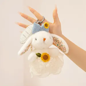 Cute plush rabbit keychain detail, fluffy bunny bag pendant with sunflower and lace skirt.