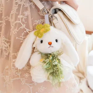Cute plush rabbit bag charm pendant detail with green floral dress and soft white fur texture.