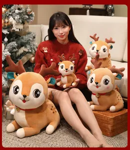 Vue détaillée de charmantes peluches de rennes de Noël avec colliers à cloches et texture douce.