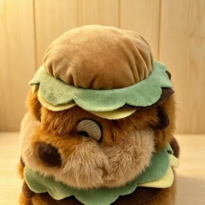 Detail view of cute plush beaver wearing a funny burger hat toy, soft fluffy stuffed animal doll.