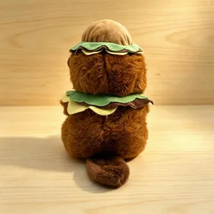 Close-up detail shot of the cute brown beaver plush toy wearing a fun burger hat and collar.