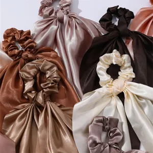Satin ribbon hair scrunchies detail shot showing various earth tone colors and smooth fabric texture.
