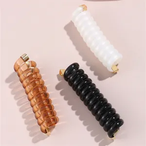 Dettaglio della molletta per capelli a spirale colorata in resina per fermare la coda.