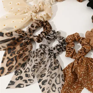 Detailed close-up view of fashionable leopard print and floral scrunchies with elegant ribbons.