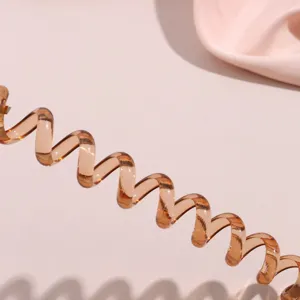 Accessorio per capelli a spirale marrone trasparente per eleganti acconciature e code di cavallo.