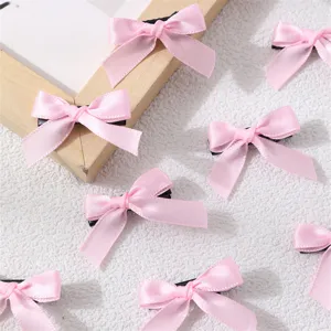 Close-up detail of sweet pink ribbon bow hair clips, cute polyester hair accessories for daily wear.