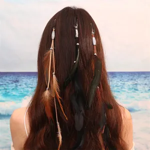Détail de pince à cheveux en plume bohème, avec plumes naturelles et perles style ethnique.