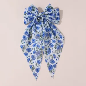 Detail view of the elegant blue floral chiffon bow hair clip, showcasing delicate fabric texture.