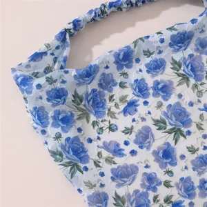 Close-up detail of the blue floral chiffon hair accessory, elegant floral print and soft fabric.