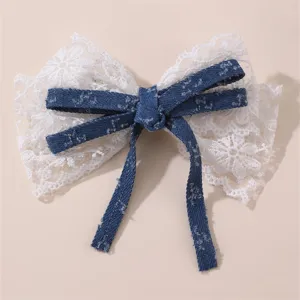 Primer plano detalle del lazo de encaje blanco y mezclilla azul con cintas.
