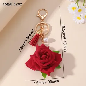 Detailed view of the sweet red rose keychain with tassel and pearl pendant for women.