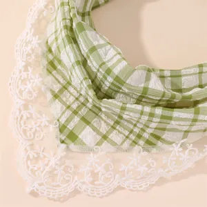 Close-up of green and white plaid hair band with delicate white floral lace trim details.